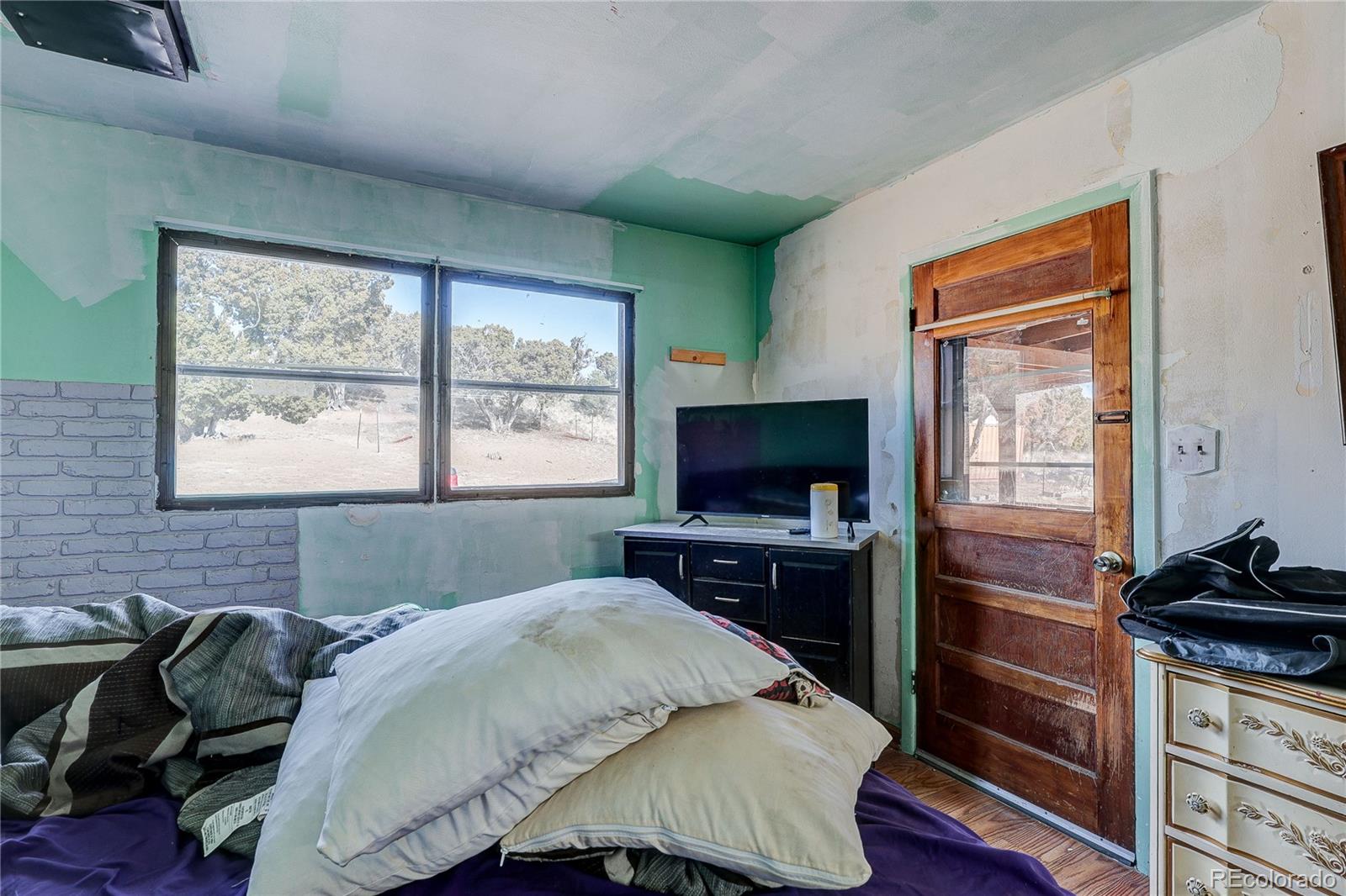 952 Twin Lakes Road Walsenburg, CO 81089 - Photo 22 of 47 a bedroom with a bed and a flat tv screen on dresser