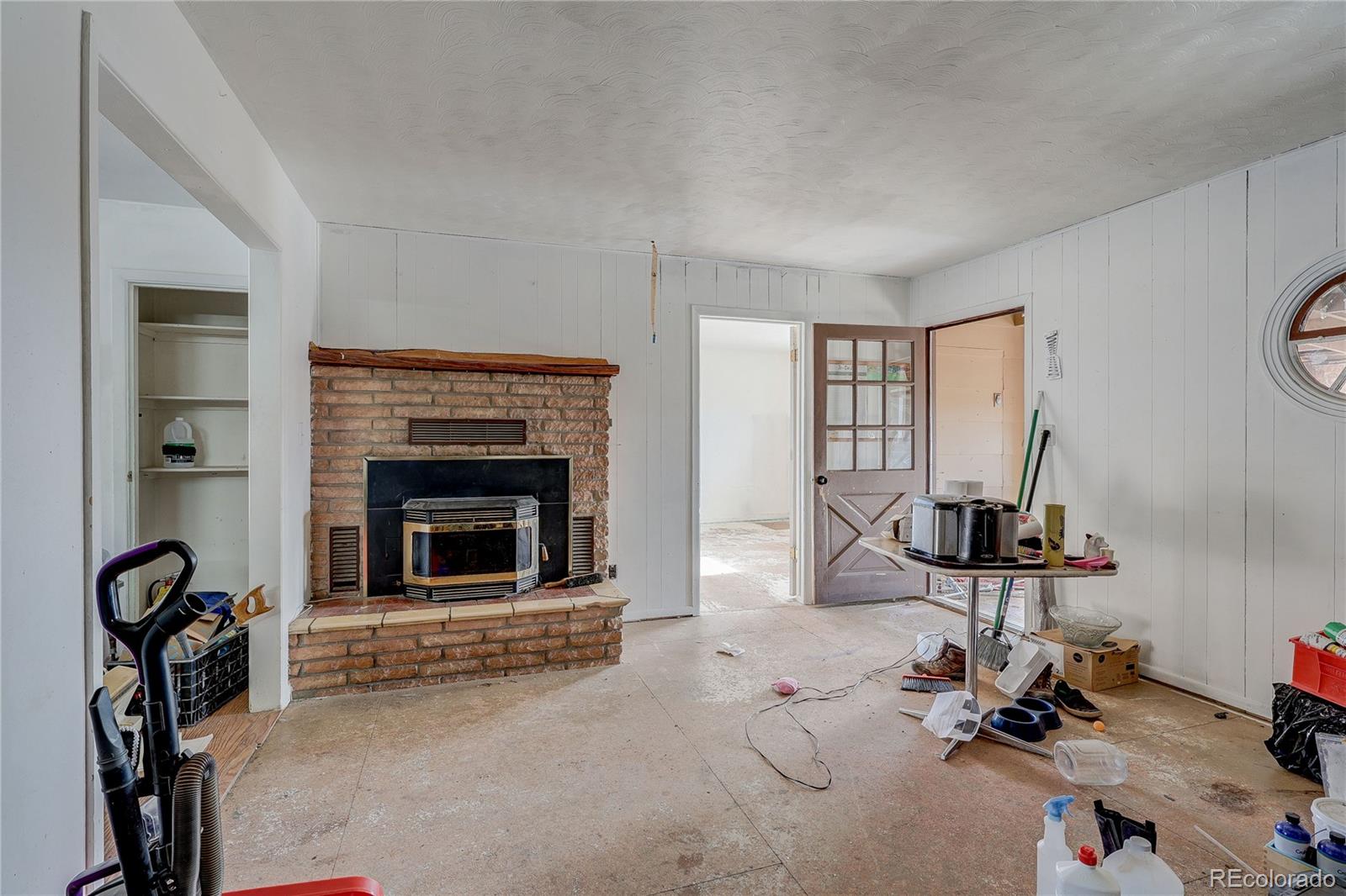 952 Twin Lakes Road Walsenburg, CO 81089 - Photo 25 of 47 a room with gym equipment and a fireplace