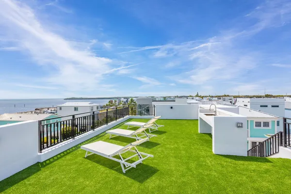 an aerial view of a house with swimming pool lawn chairs and wooden fence