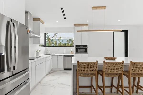 a kitchen with stainless steel appliances a table chairs and a refrigerator