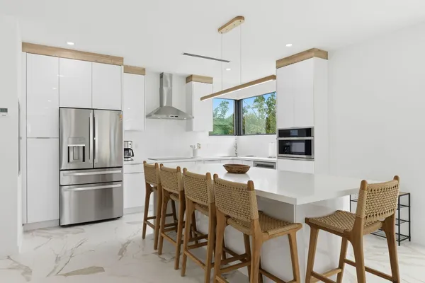 a kitchen with white cabinets and appliances