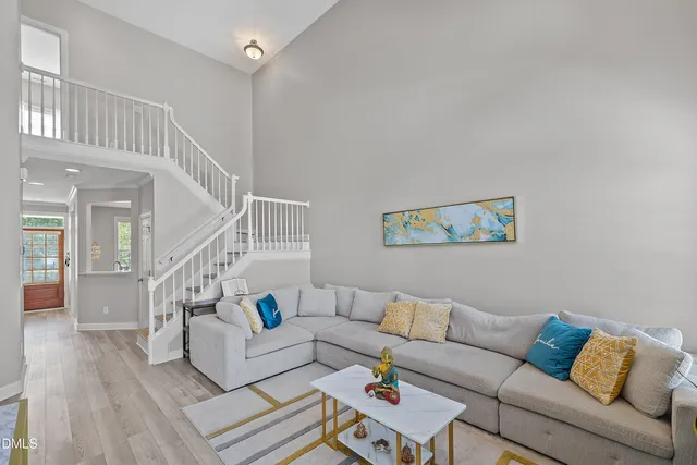 a view of a livingroom with furniture fireplace wooden floor and windows