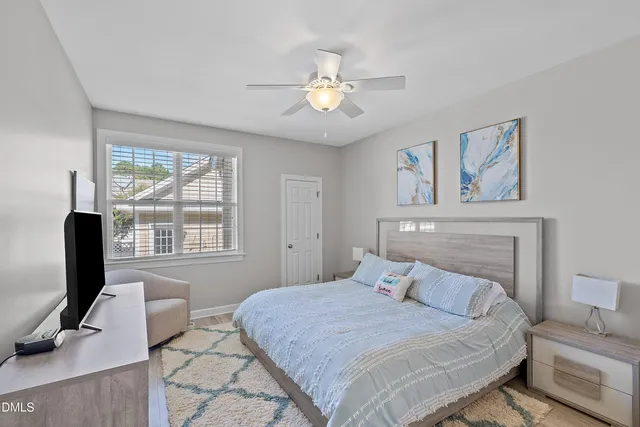 a bedroom with a bed and a flat tv screen on dresser