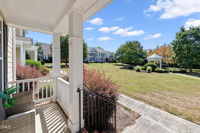 a front view of a house with garden and trees