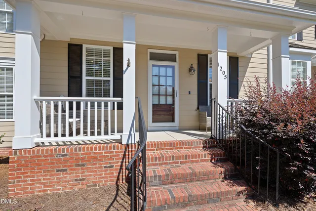 a dining room with wooden floor a chandelier a wooden table and chairs