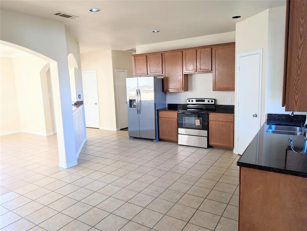 1223 Georgia Avenue Dallas, TX 75216 - Photo 4 of 13 a kitchen with stainless steel appliances granite countertop a refrigerator stove and sink