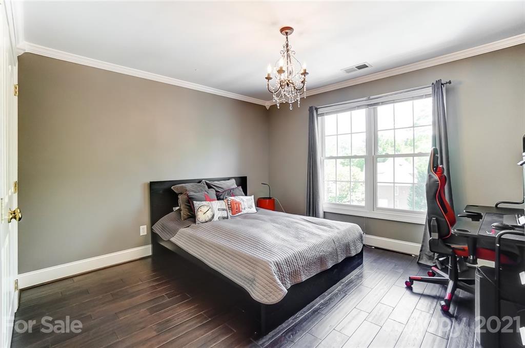 7126 Topsail Circle Tega Cay, SC 29708 - Photo 34 of 48 a bedroom with a bed and a chandelier