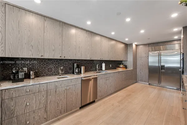 a view of a kitchen with a sink cabinets and stainless steel appliances