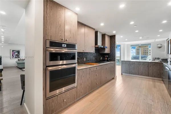 a kitchen with stainless steel appliances kitchen island granite countertop a stove a sink and a microwave