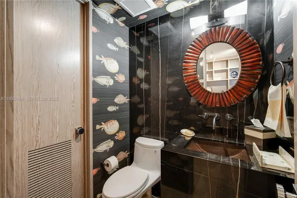 a bathroom with a toilet sink and mirror