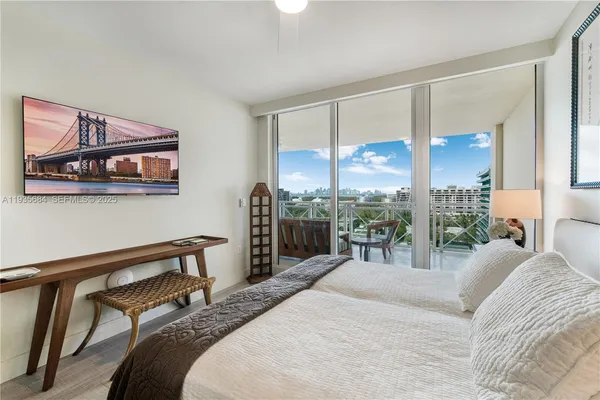 a bedroom with a bed a large window and potted plant on the table