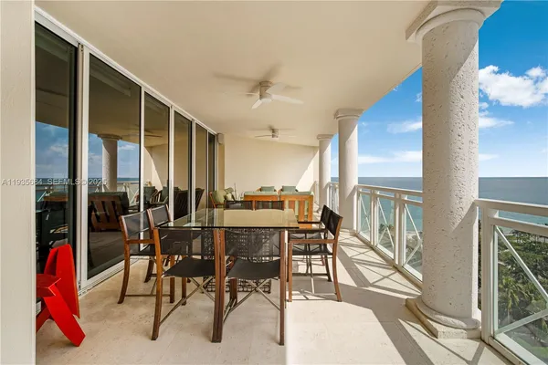 a dining area with furniture and a floor to ceiling window