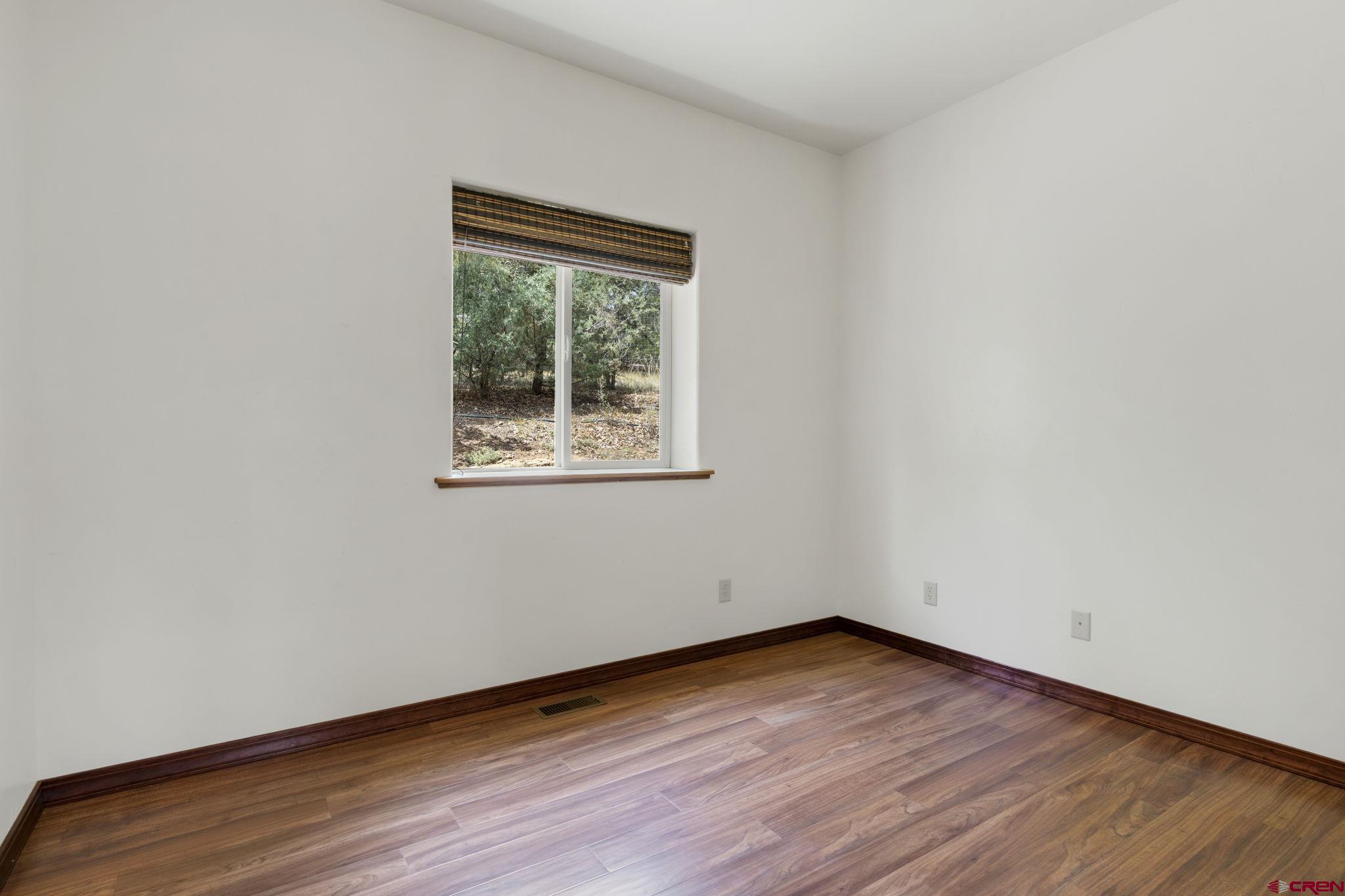 564 Spring Road Durango, CO 81303 - Photo 31 of 45 a view of an empty room with wooden floor and a window