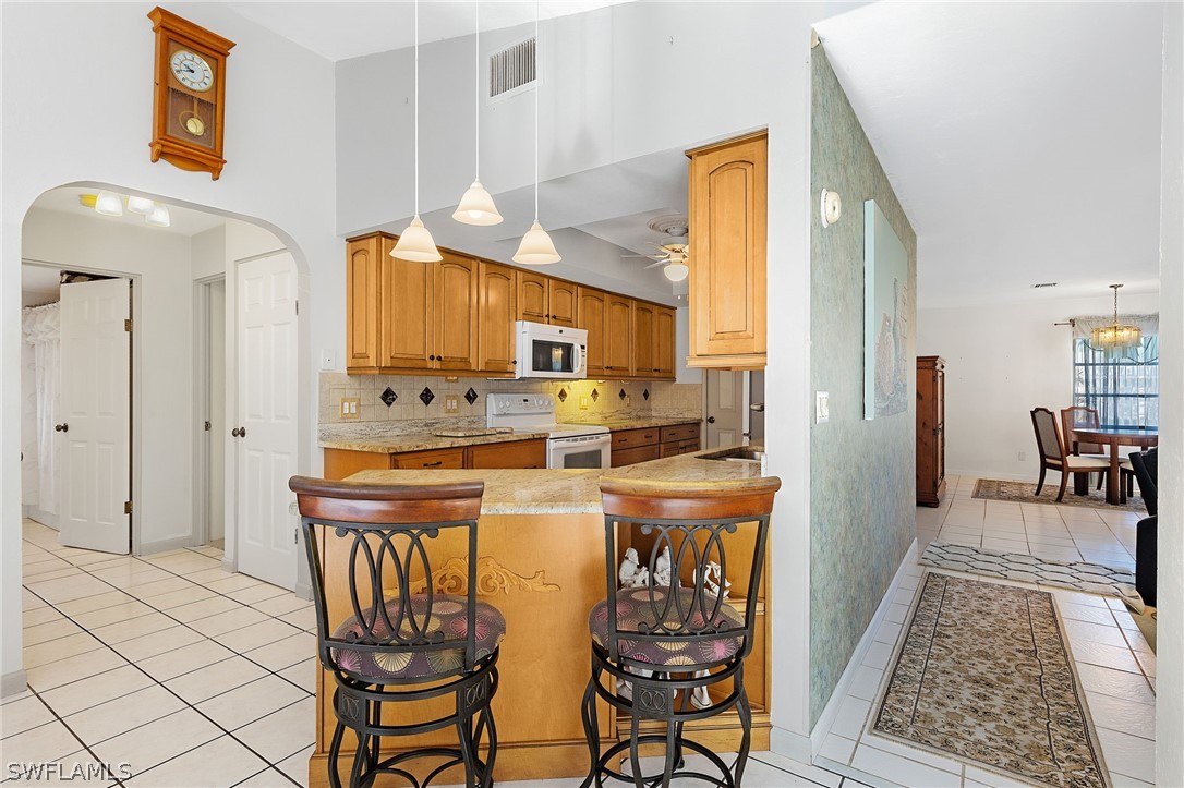 17501 Laurel Valley Road Fort Myers, FL 33967 - Photo 14 of 26 a kitchen with stainless steel appliances kitchen island granite countertop a refrigerator and a stove