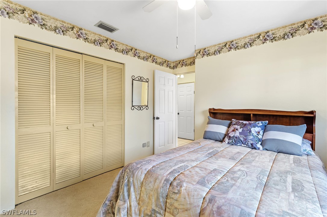 17501 Laurel Valley Road Fort Myers, FL 33967 - Photo 10 of 26 a bedroom with a large bed and a chandelier