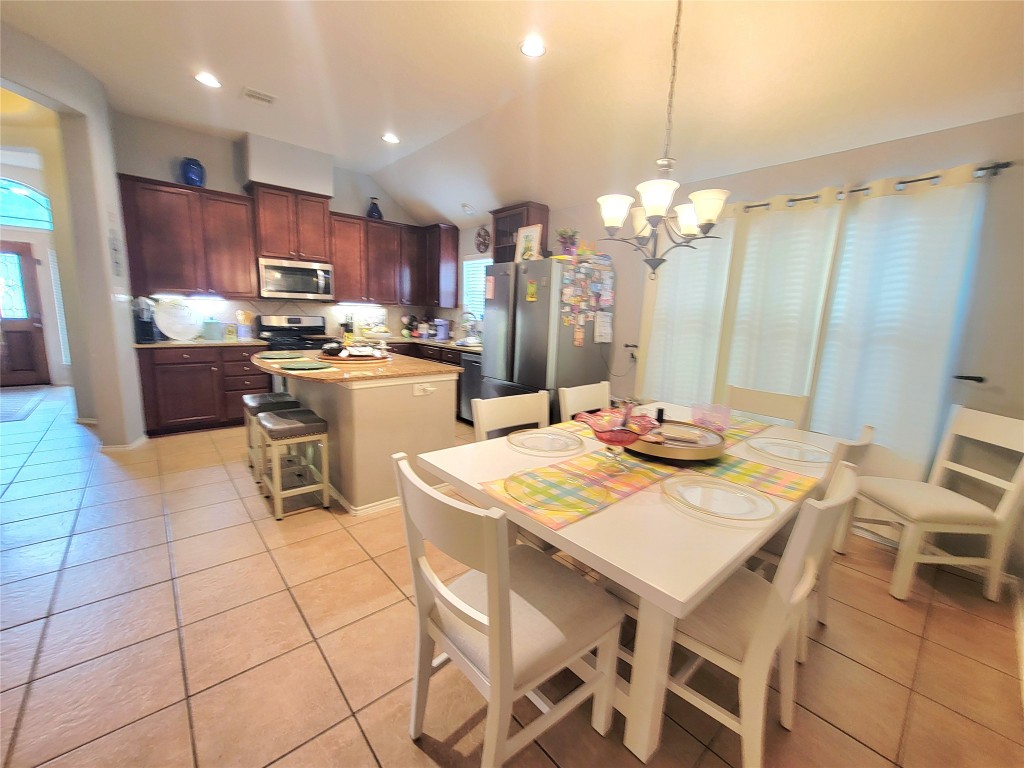 219 Golden Grain Drive Rosenberg, TX 77469 - Photo 9 of 17 a kitchen with stainless steel appliances kitchen island granite countertop a sink a stove a dining table and chairs