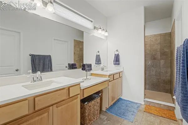a spacious bathroom with a double vanity sink mirror and shower