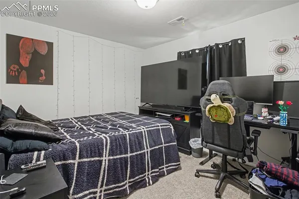 a bedroom with bed and a flat tv screen