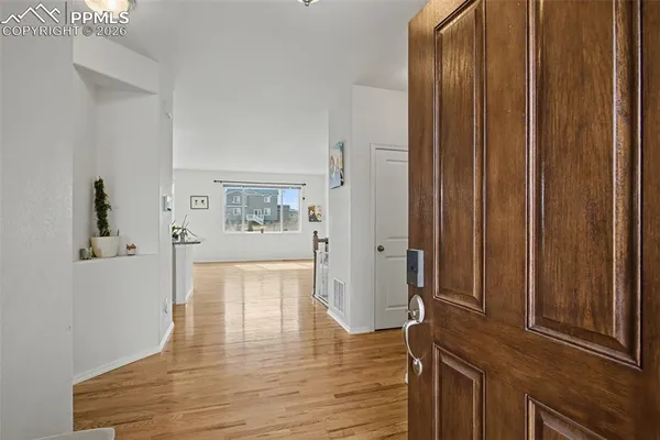 a view of a hallway with wooden floor and windows
