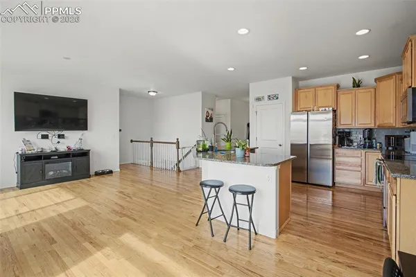 a view of kitchen with stainless steel appliances kitchen island granite countertop a stove a sink a dining table and chairs