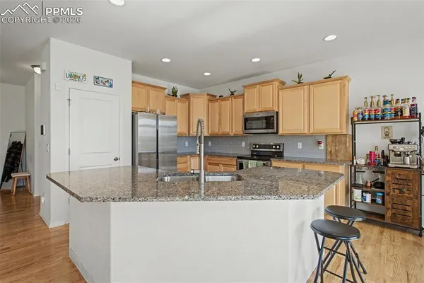 a kitchen with stainless steel appliances granite countertop a sink refrigerator and cabinets