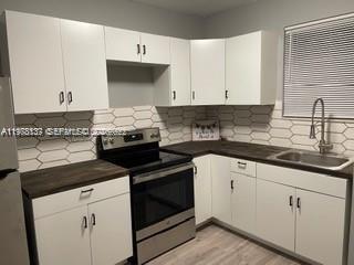 842 Southwest 3rd Street, Unit 844 Miami, FL 33130 - Photo 2 of 11 a kitchen with granite countertop white cabinets and black appliances