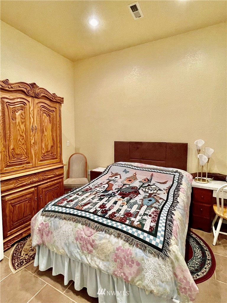 19229 Patterson Road East Orting, WA 98360 - Photo 22 of 35 a bedroom with a bed and wooden floor