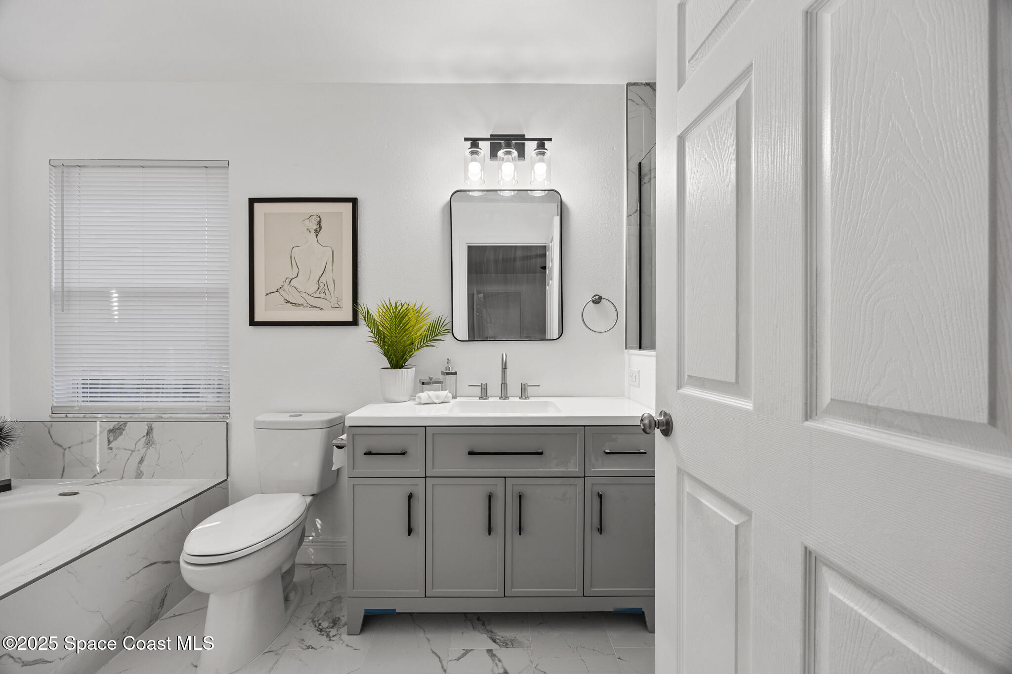 3568 Egret Drive Melbourne, FL 32901 - Photo 13 of 27 a bathroom with a toilet a sink and mirror