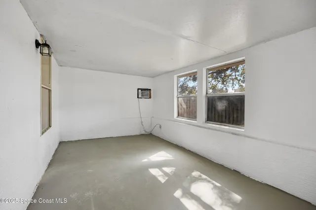 an empty room with a window and a ceiling fan