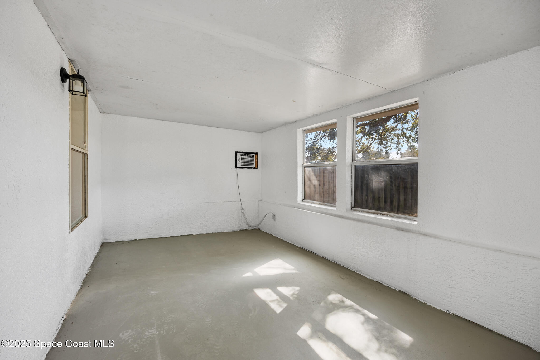3568 Egret Drive Melbourne, FL 32901 - Photo 21 of 27 an empty room with windows and fireplace