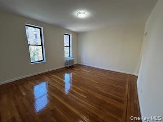 83-52 Talbot Street, Unit 3J Queens, NY 11415 - Photo 11 of 50 a view of an empty room with wooden floor and a window