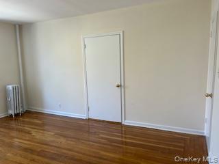 83-52 Talbot Street, Unit 3J Queens, NY 11415 - Photo 20 of 50 a view of an empty room with wooden floor