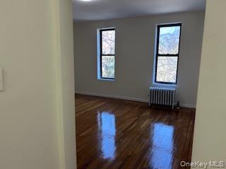 83-52 Talbot Street, Unit 3J Queens, NY 11415 - Photo 30 of 50 an empty room with wooden floor and windows