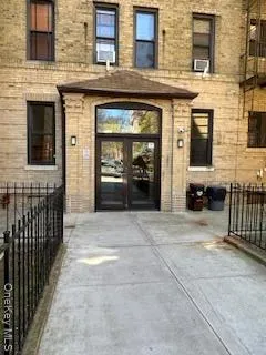 a view of a brick house with a door and a large window