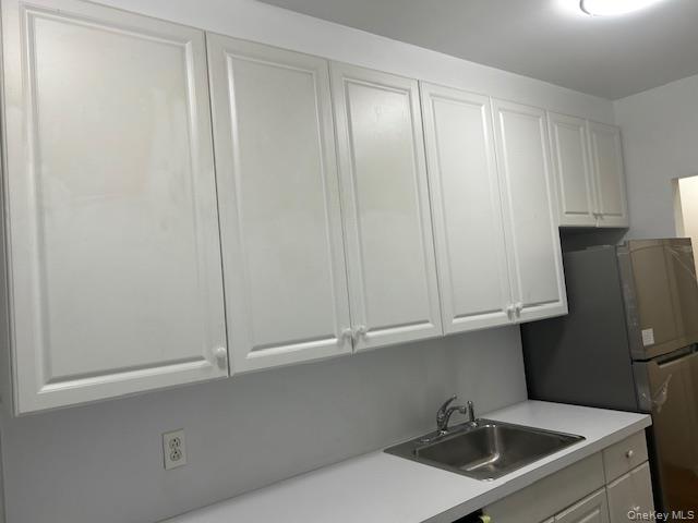 83-52 Talbot Street, Unit 3J Queens, NY 11415 - Photo 35 of 50 a kitchen with stainless steel appliances white cabinets and a sink