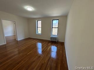 83-52 Talbot Street, Unit 3J Queens, NY 11415 - Photo 10 of 50 an empty room with wooden floor and windows