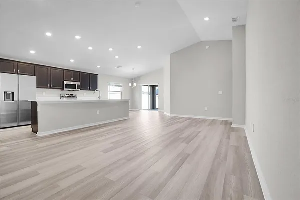 a view of kitchen with cabinets microwave and refrigerator