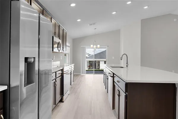 a kitchen with kitchen island granite countertop a sink stove and cabinets
