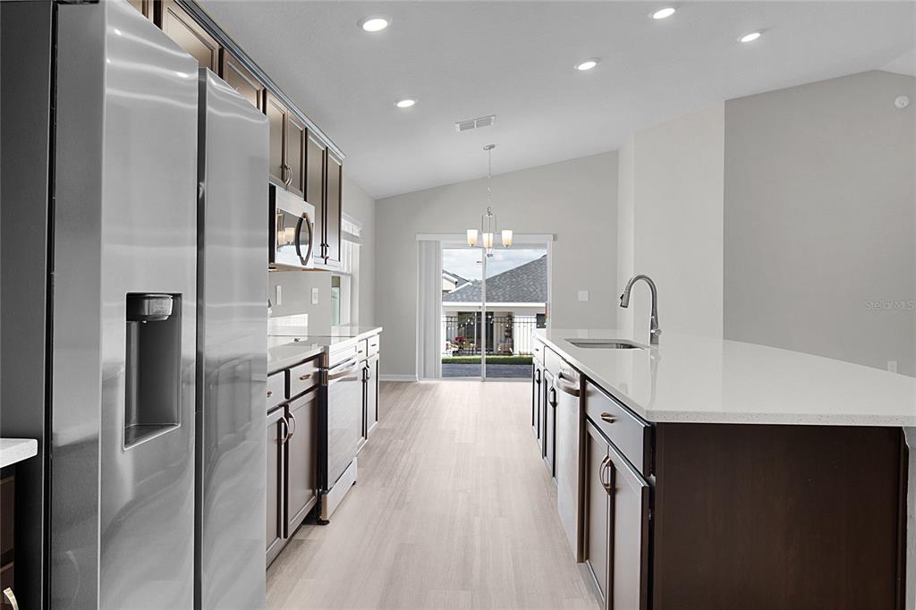 1617 Astrid Road Davenport, FL 33837 - Photo 21 of 43 a kitchen with stainless steel appliances a sink stove and refrigerator
