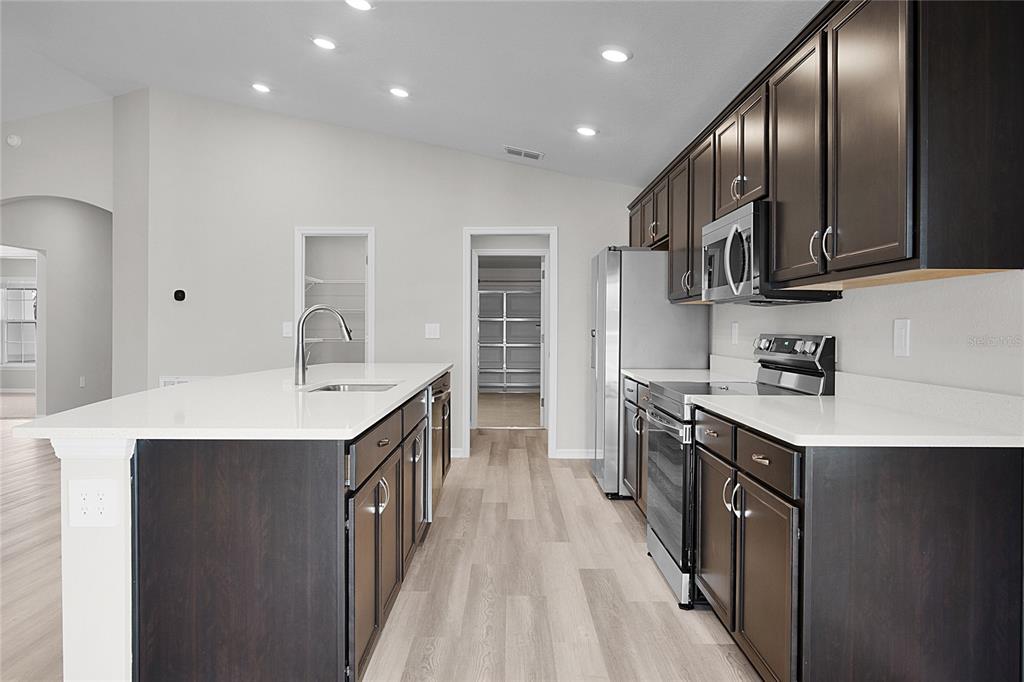 1617 Astrid Road Davenport, FL 33837 - Photo 22 of 43 a kitchen with kitchen island granite countertop a sink stove and cabinets