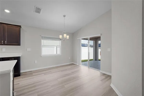 a view of a kitchen and an empty room