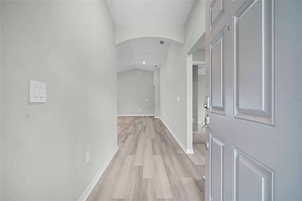 1617 Astrid Road Davenport, FL 33837 - Photo 9 of 43 a view of a hallway with wooden floor and entryway
