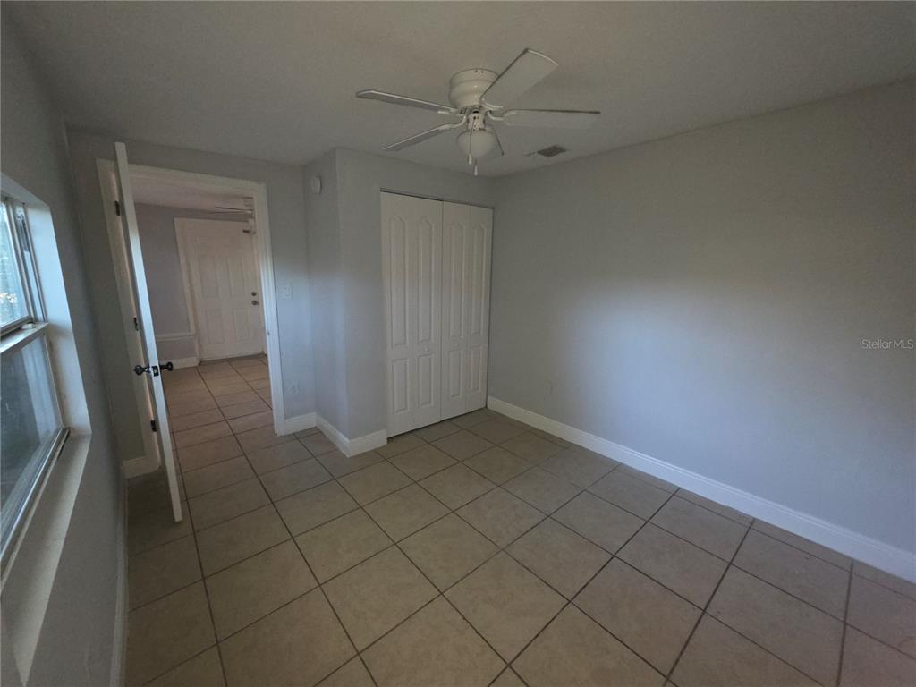 1344 Wickham Lane Holiday, FL 34691 - Photo 11 of 17 an empty room with wooden floor and fan