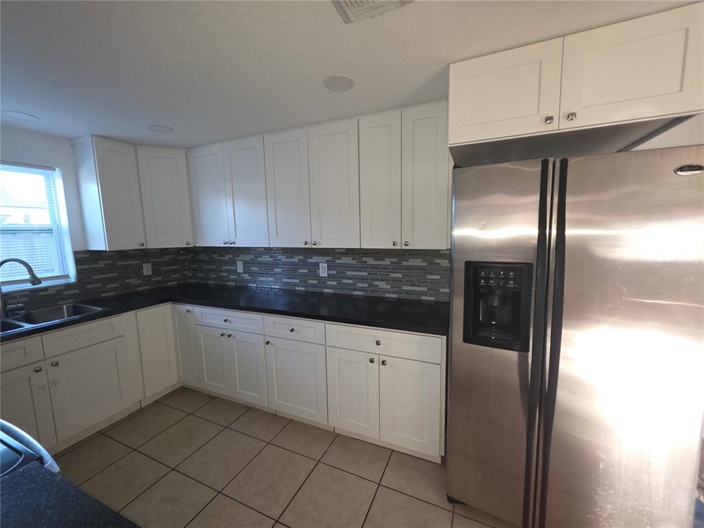 1344 Wickham Lane Holiday, FL 34691 - Photo 4 of 17 a kitchen with granite countertop white cabinets and stainless steel appliances