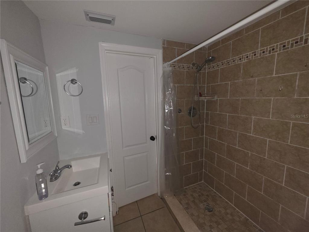 1344 Wickham Lane Holiday, FL 34691 - Photo 8 of 17 a bathroom with a glass door shower