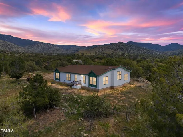 a view of a house with a yard and mountain view
