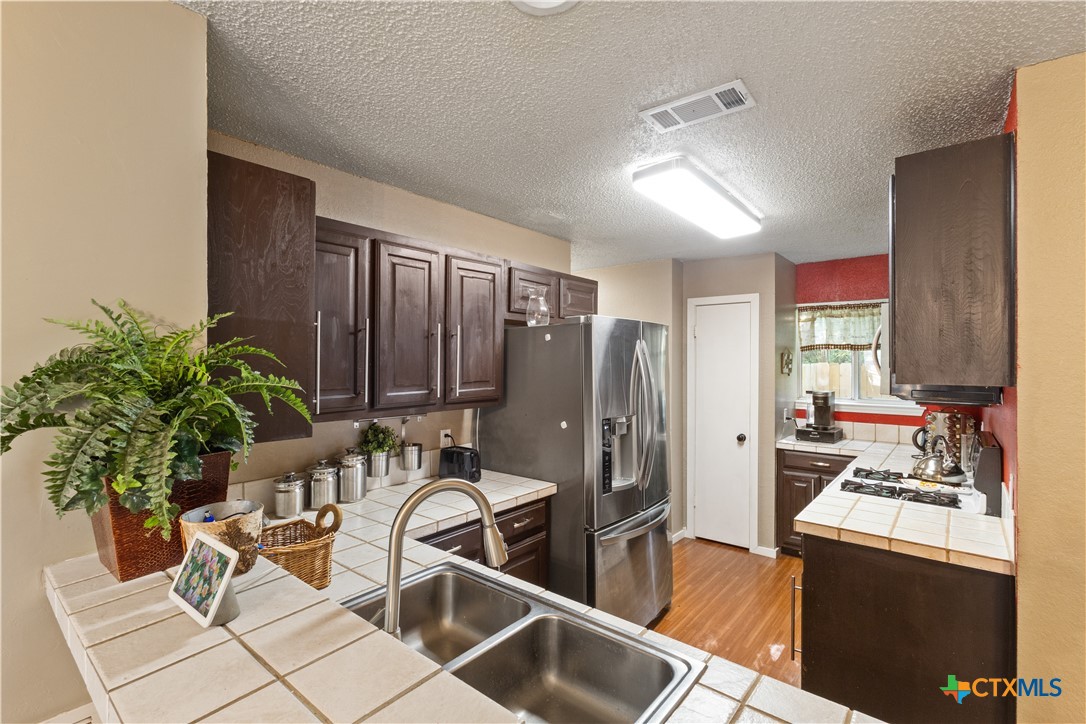 2107 Raintree Path Round Rock, TX 78664 - Photo 15 of 35 a kitchen with a table chairs refrigerator and stove