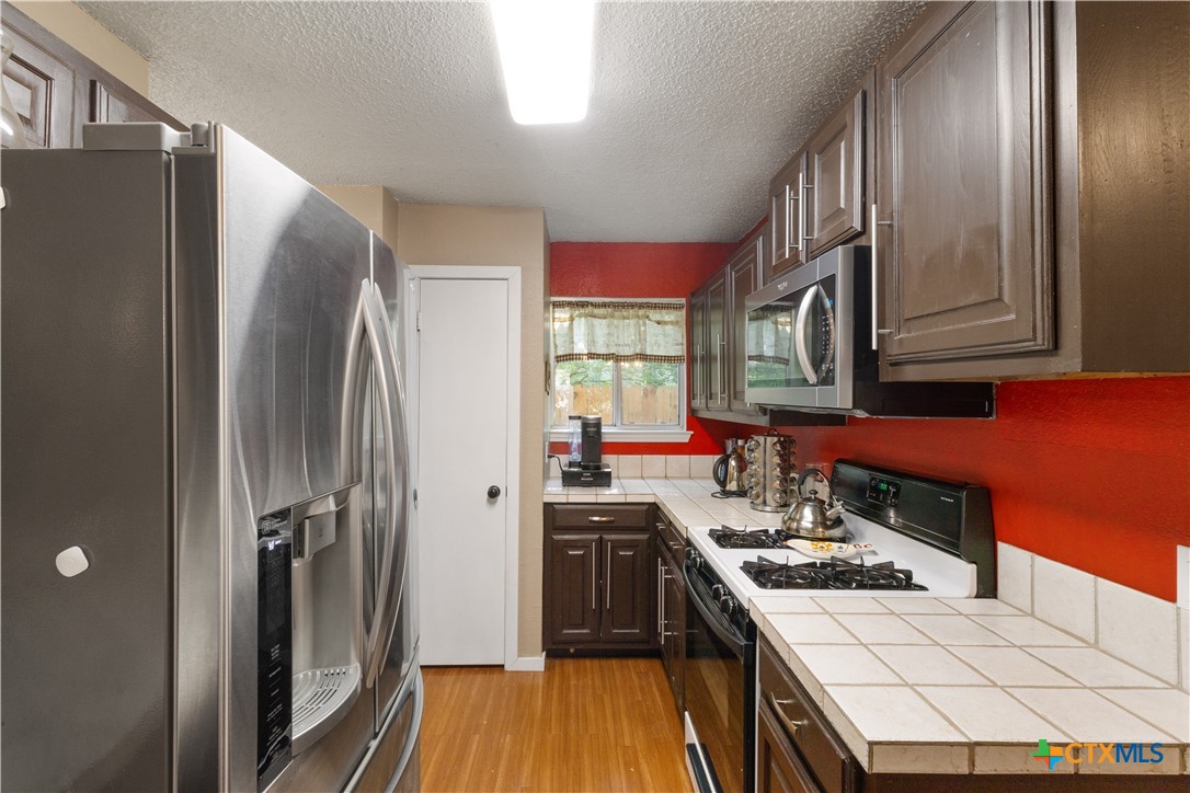 2107 Raintree Path Round Rock, TX 78664 - Photo 17 of 35 a kitchen with a sink stove and refrigerator