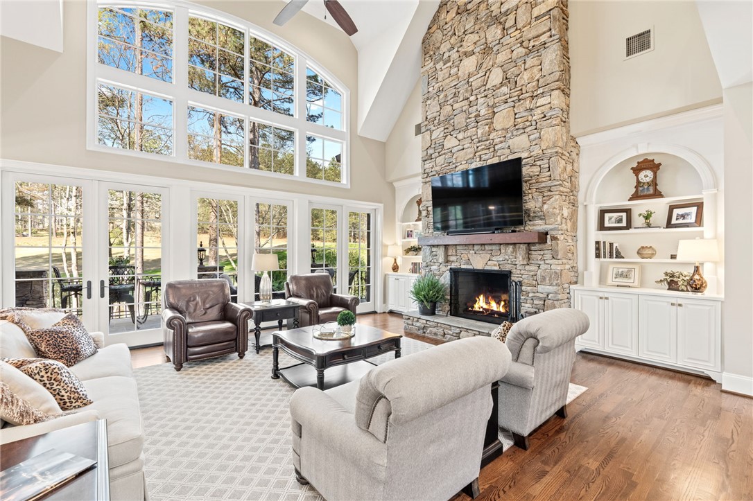 418 Augusta Way Sunset, SC 29685 - Photo 7 of 50 This grand living area features a towering stone fireplace, elegant built-in shelving, and expansive outdoor views.