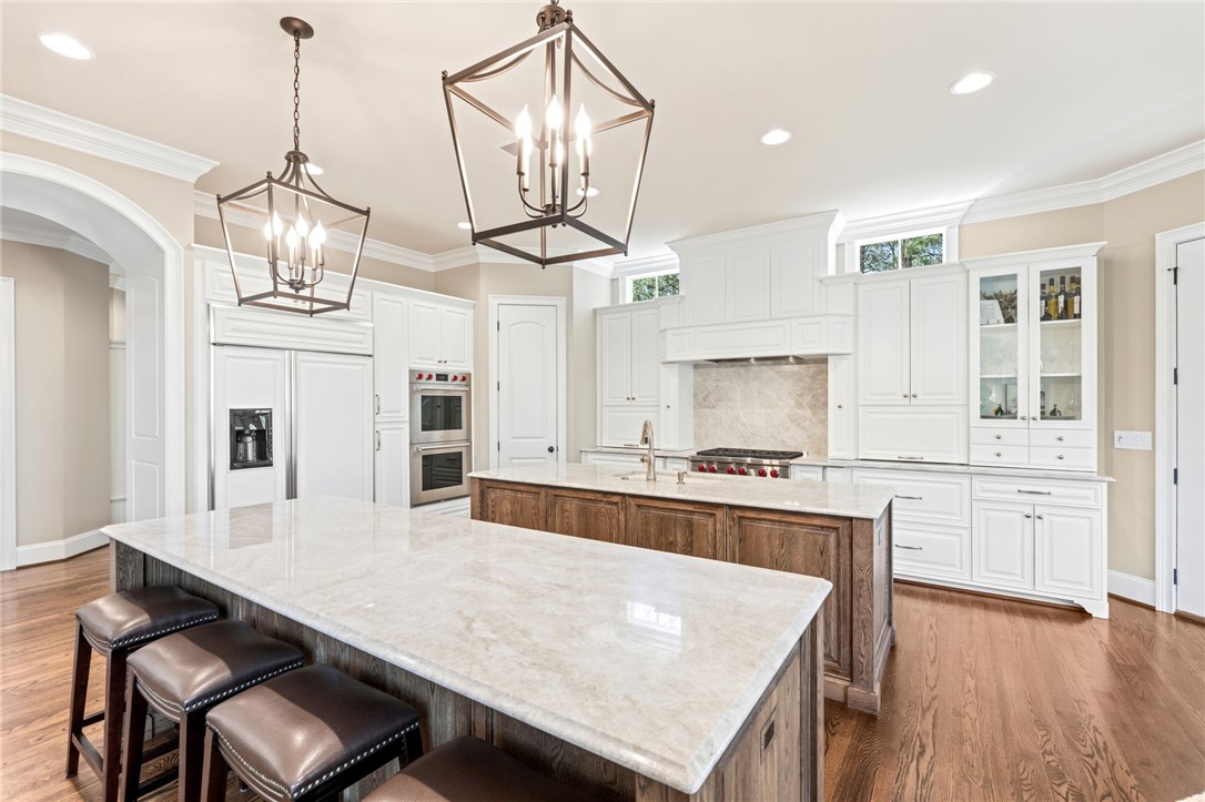 418 Augusta Way Sunset, SC 29685 - Photo 8 of 50 This spacious kitchen offers double islands, pristine white cabinetry, and gleaming hardwood floors.
